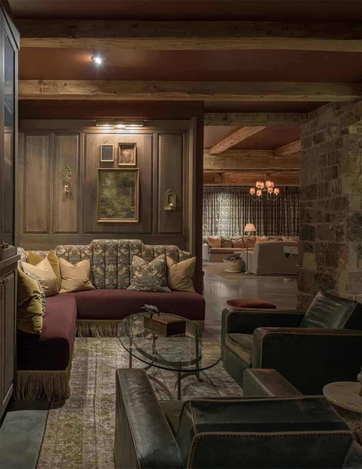 Cozy lounge with tufted floral sofa, leather chairs, and view to living room beyond