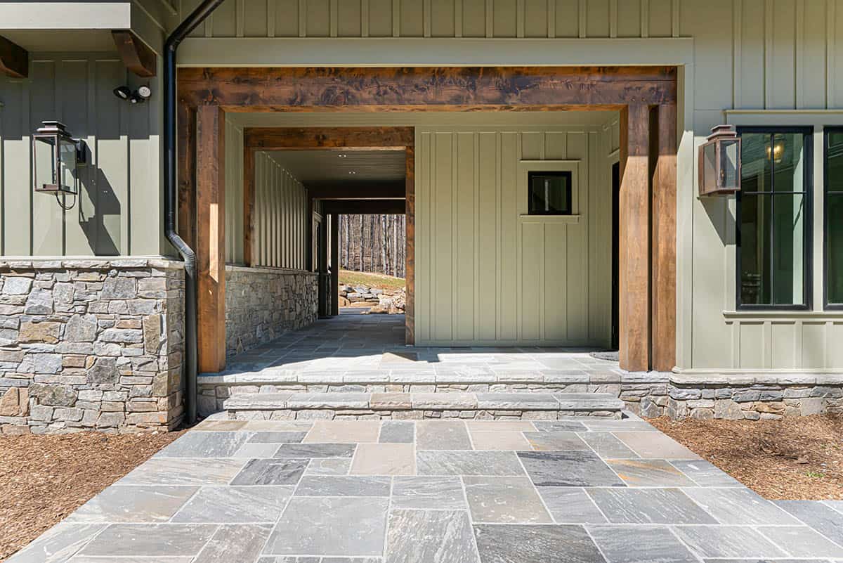 Breezeway with timber posts and stone walls leading to garage