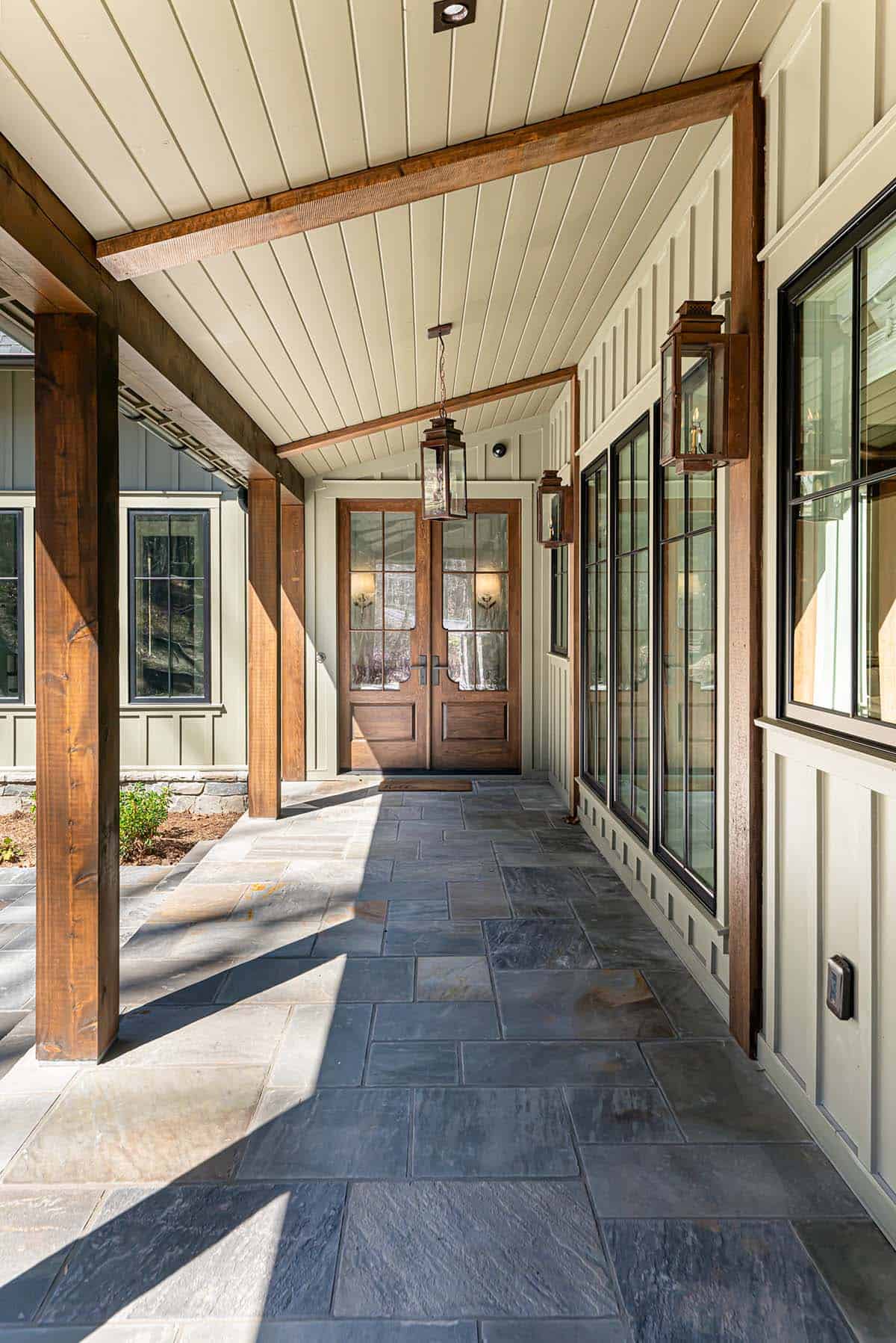 Covered entry walkway with timber beams and double front door