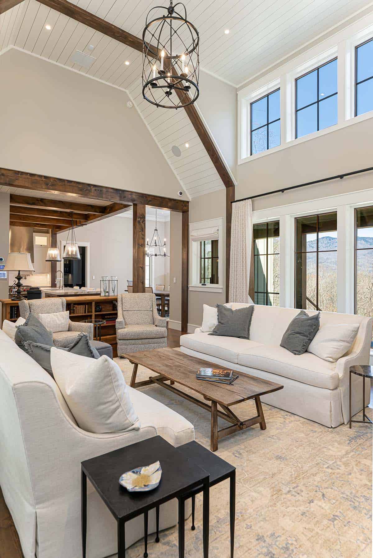 Living room with timber beams and mountain views through windows