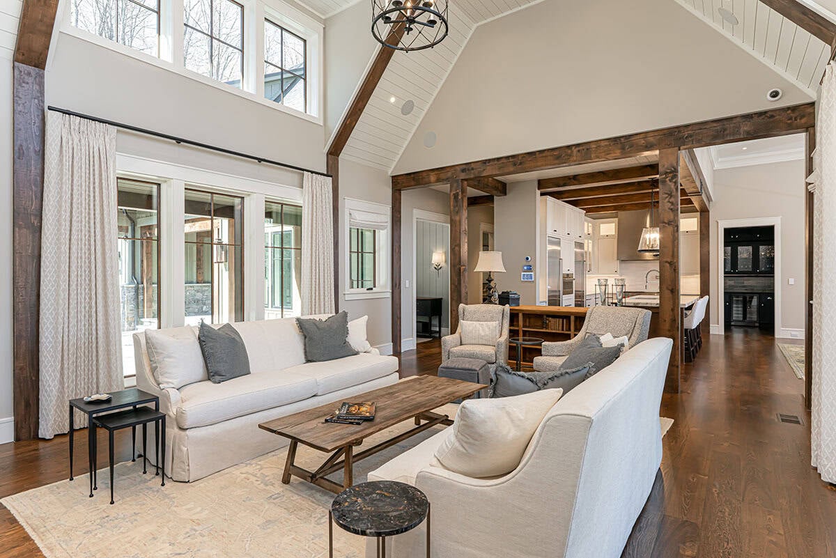 Open-concept living room and kitchen with timber beam accents