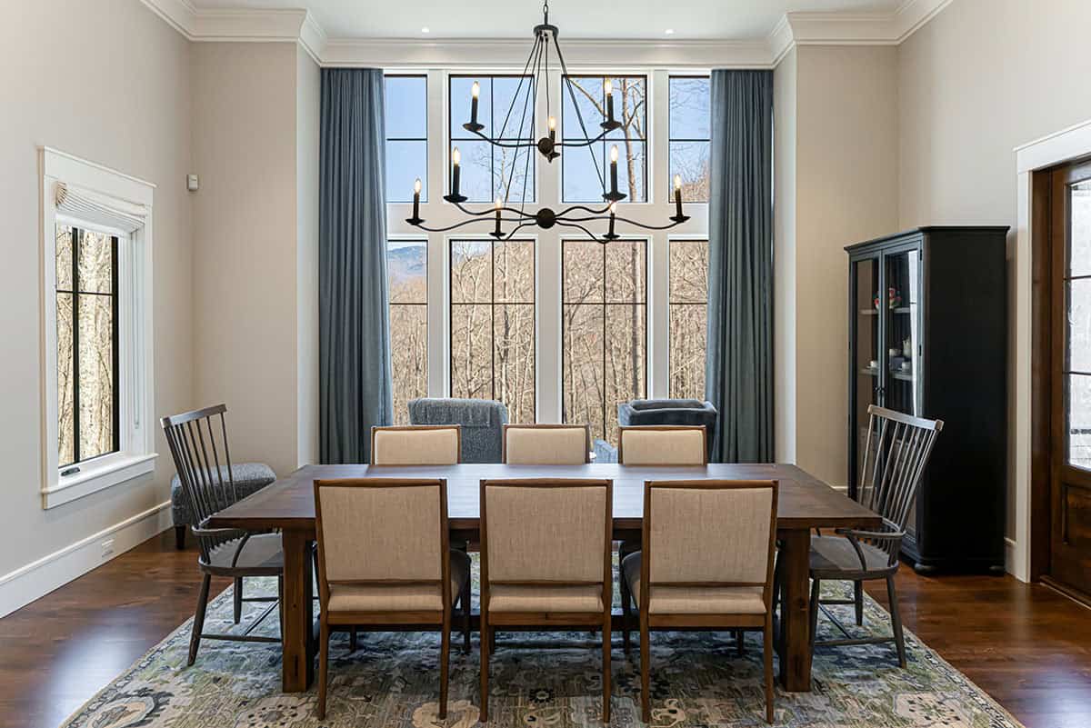 Dining room with iron chandelier and forest views
