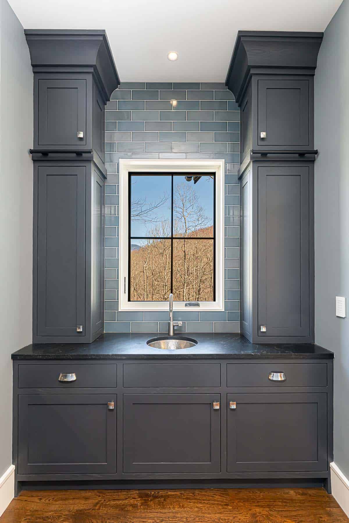 Wet bar with blue subway tile and mountain view window