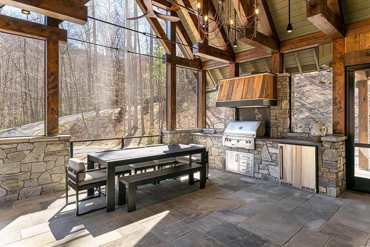 Screened outdoor kitchen with stone counters and dining table
