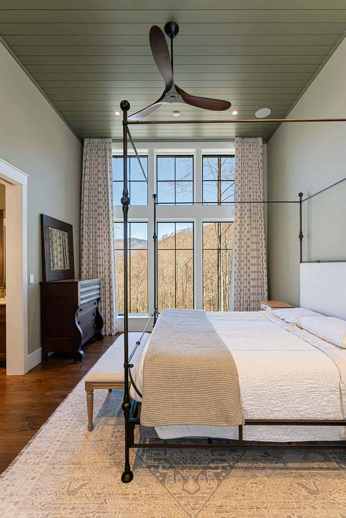 Primary bedroom with canopy bed and mountain view windows
