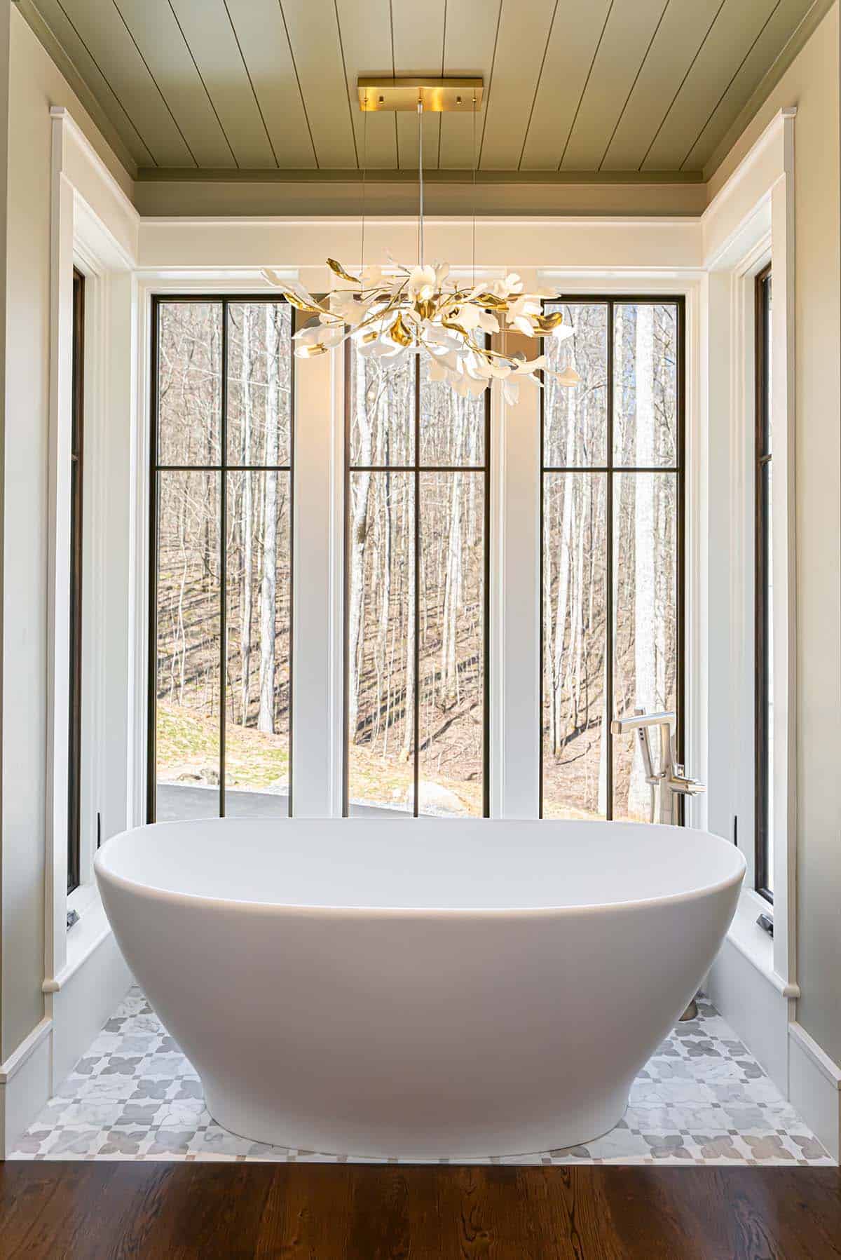 Freestanding tub with floral pendant light and forest view