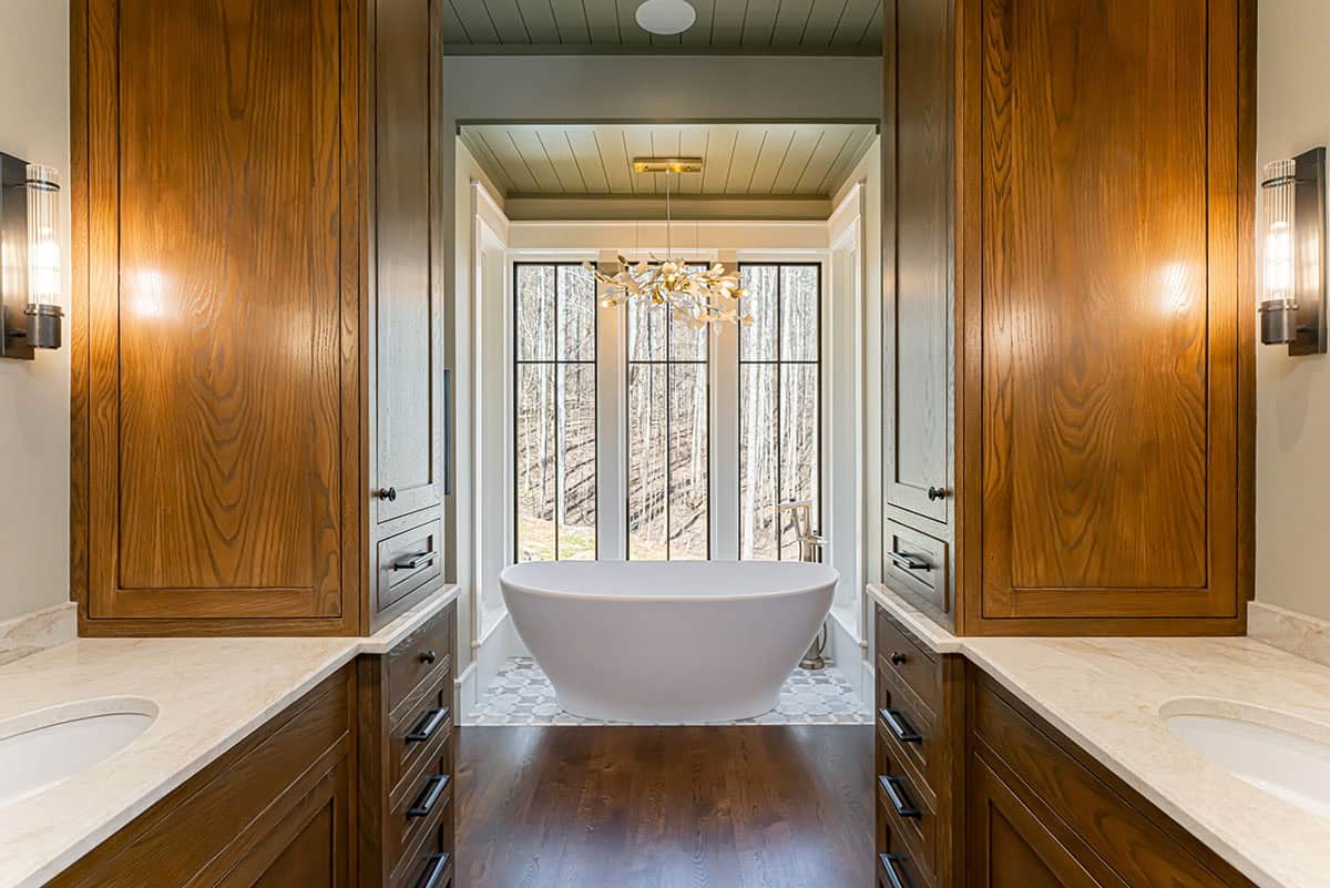 Primary bathroom with freestanding tub and floral pendant light