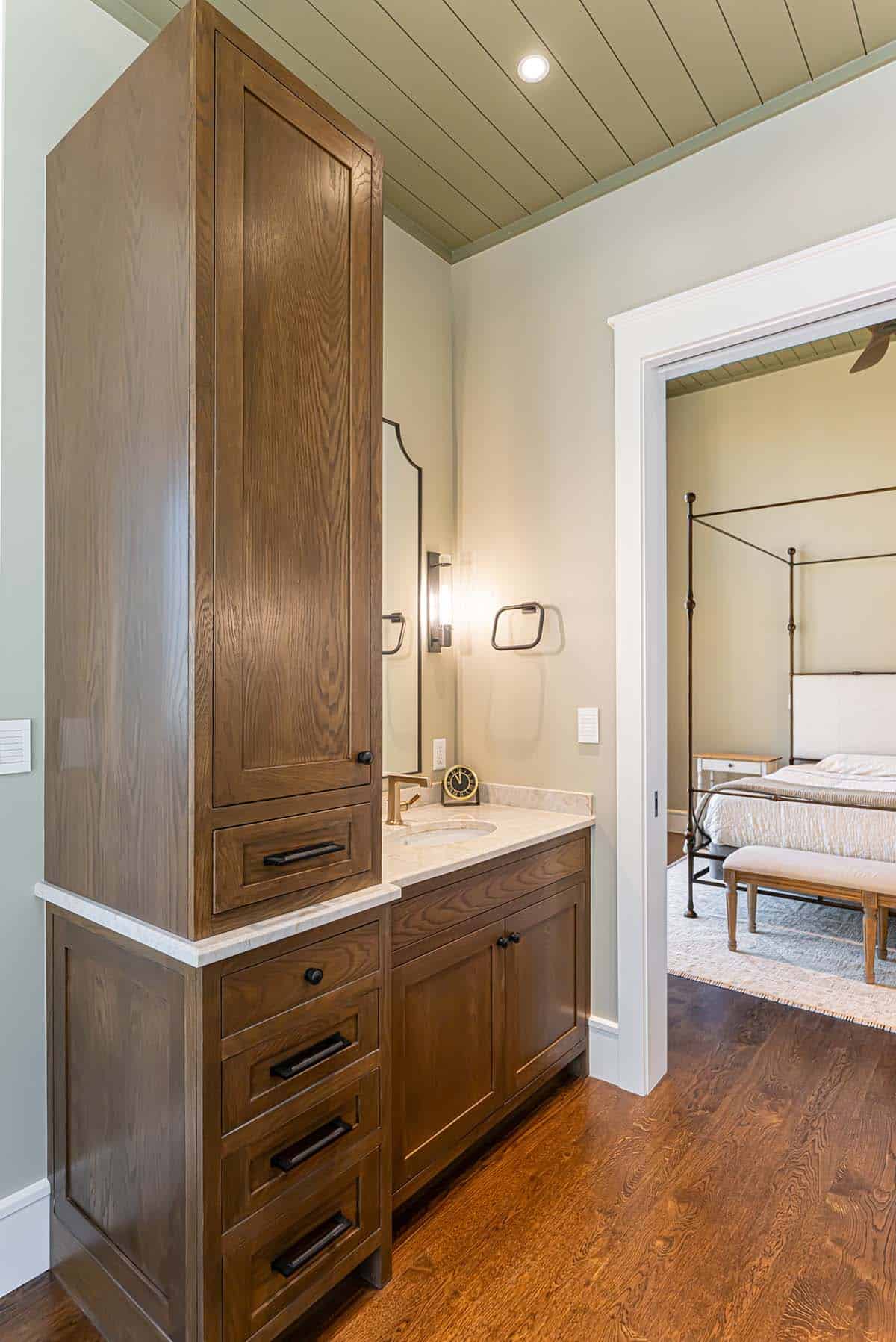 Bathroom vanity with view into bedroom with canopy bed