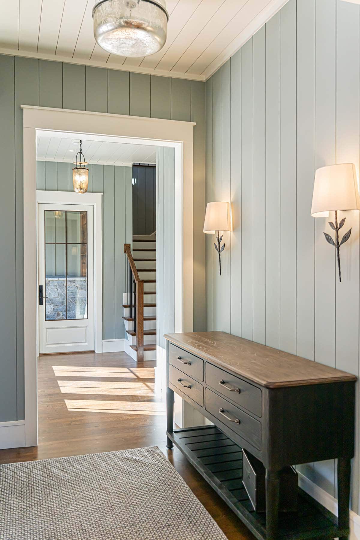 Entryway with paneled walls and antique console table