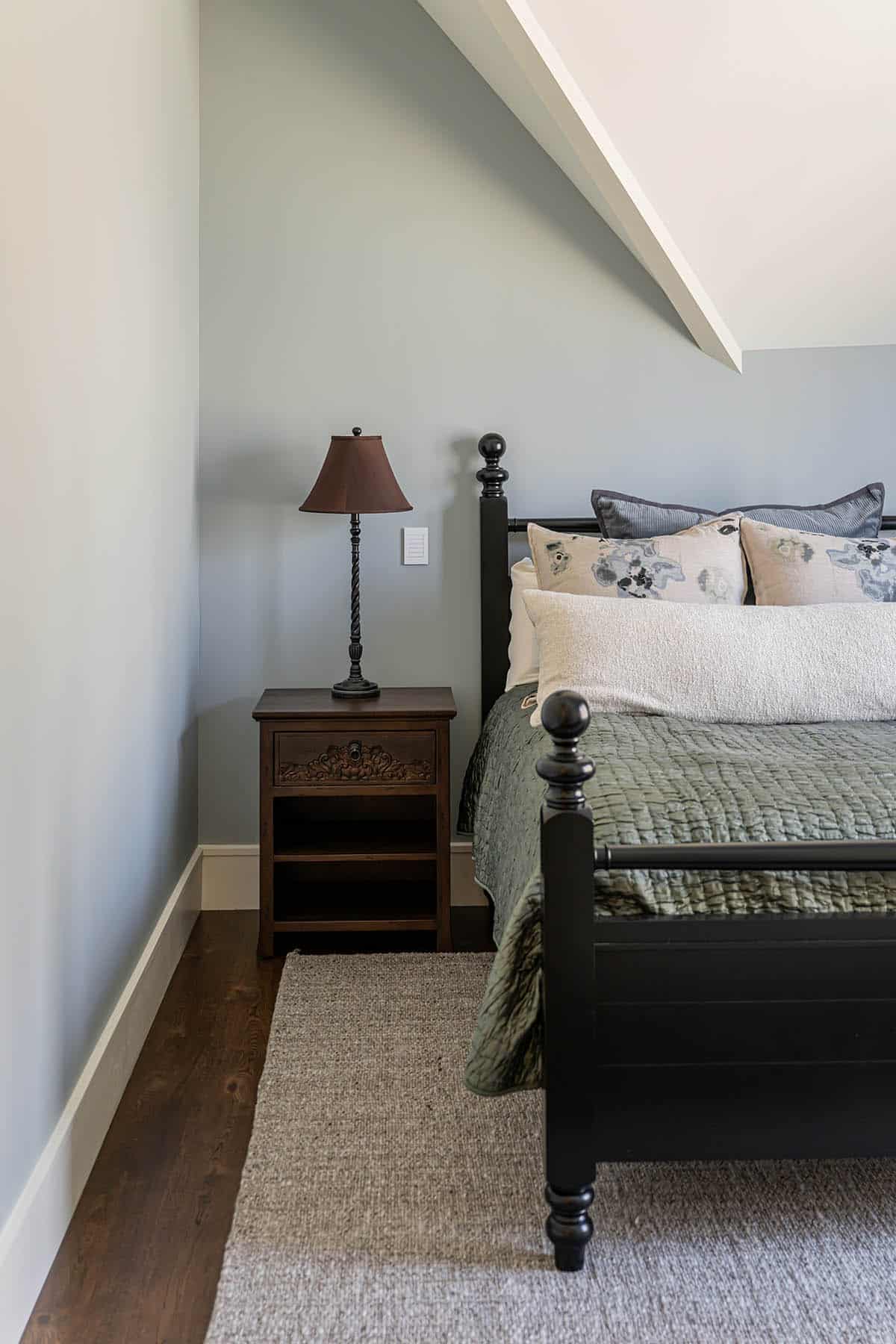 Bedroom nightstand detail with black four-poster bed