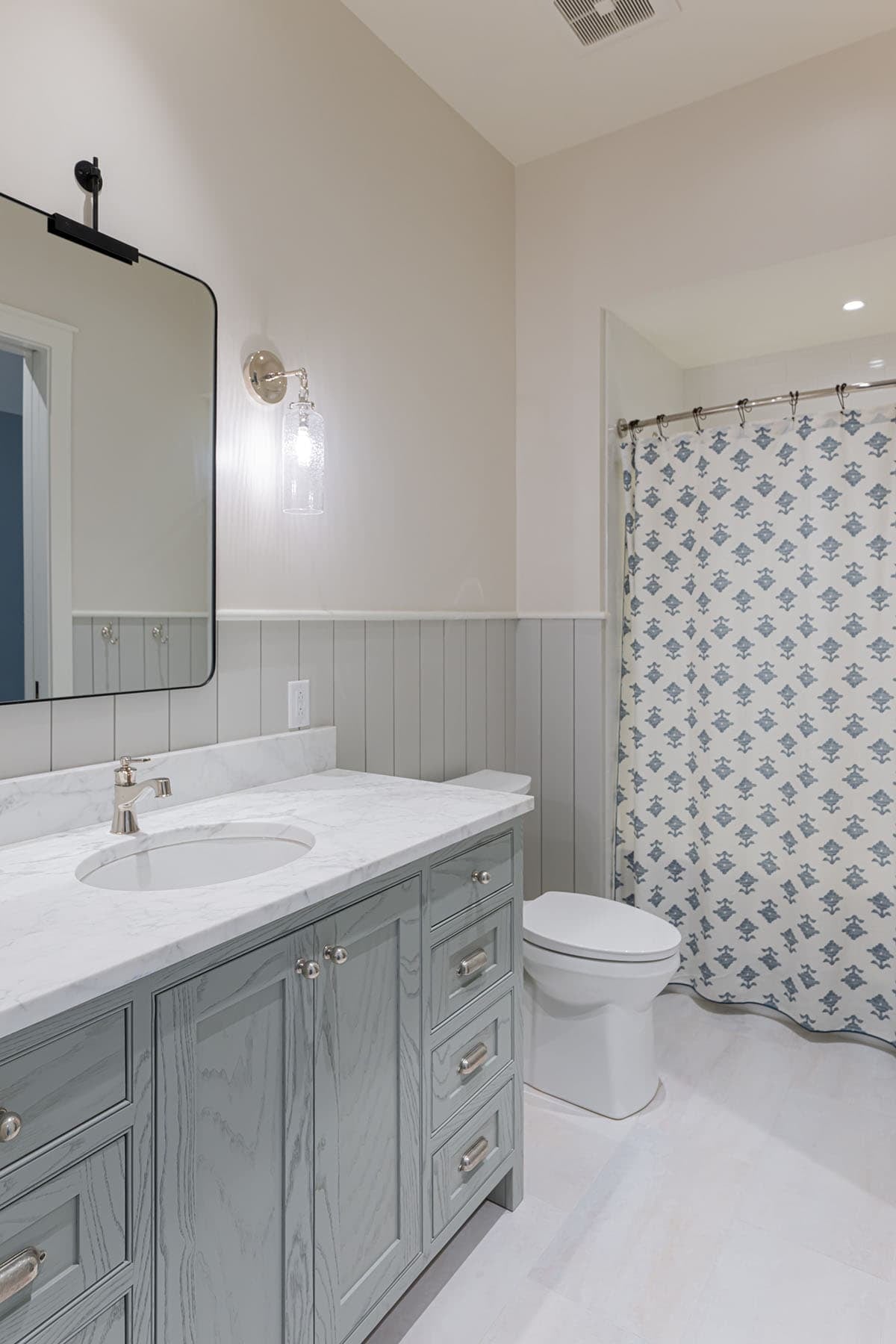 Bathroom with gray vanity and patterned shower curtain