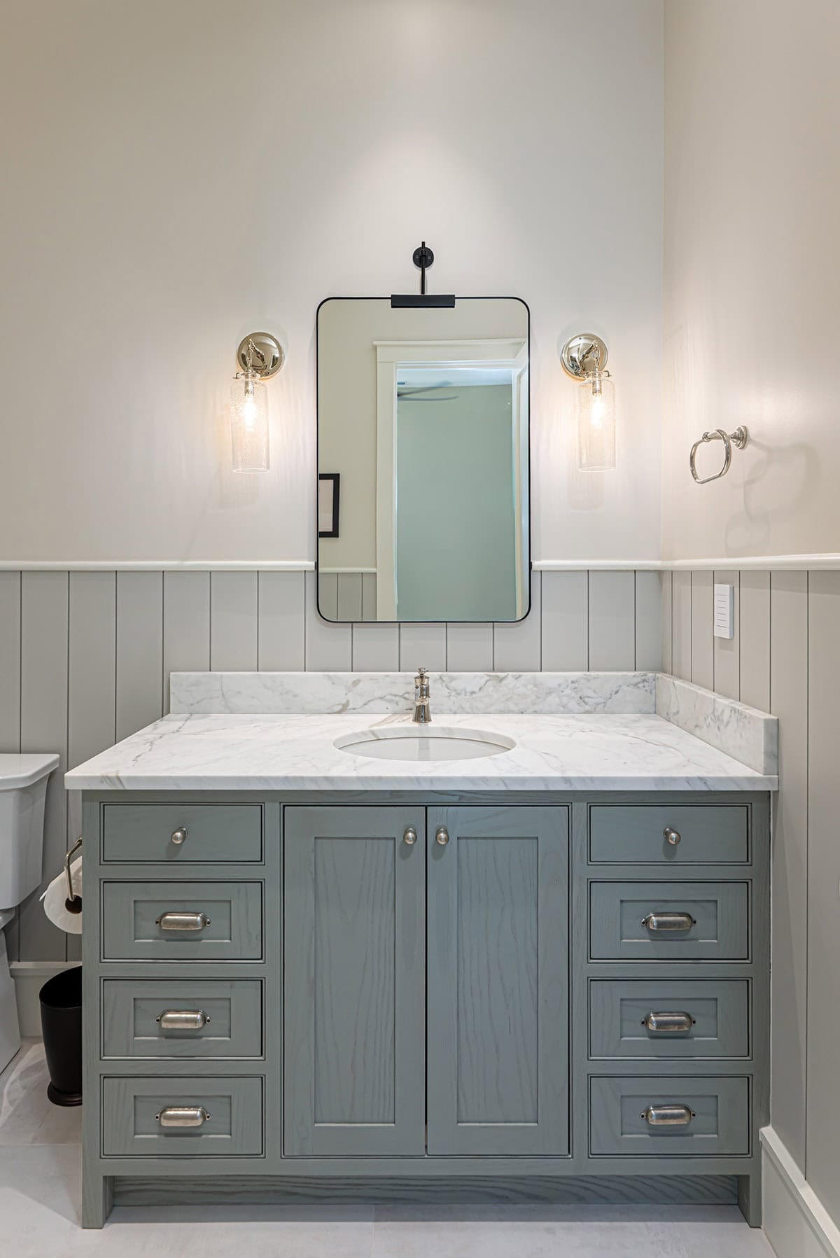 Bathroom vanity with gray cabinetry and marble countertop
