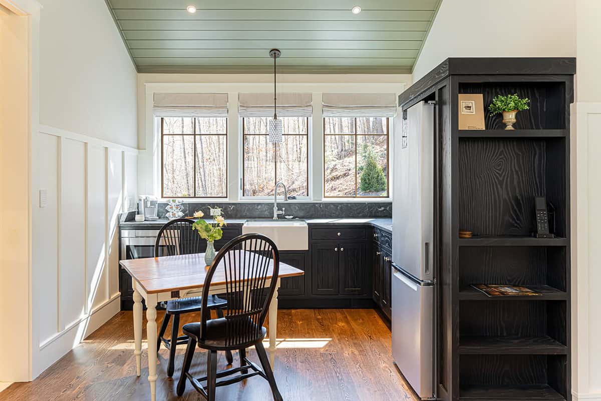 Guest suite kitchenette with farmhouse table and black chairs