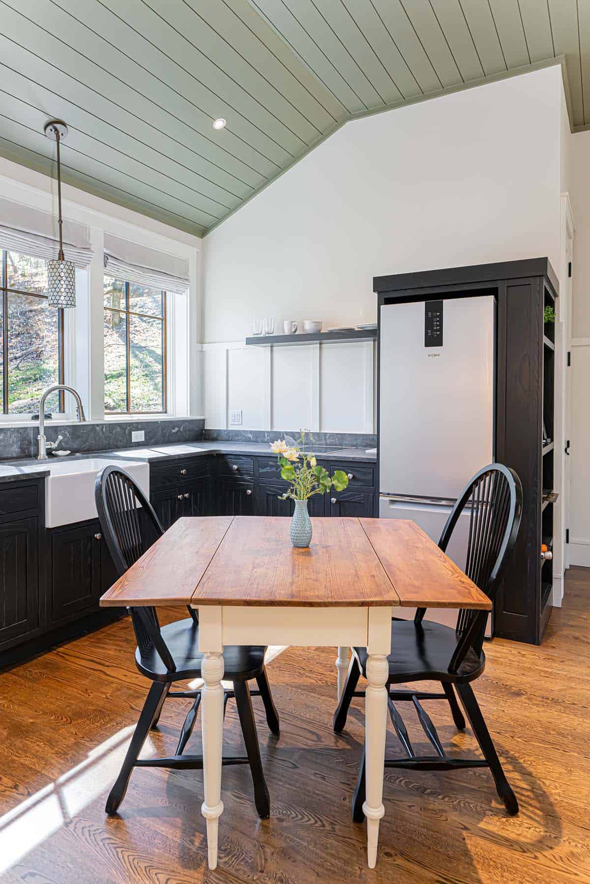 Guest suite dining nook with farmhouse table and forest view