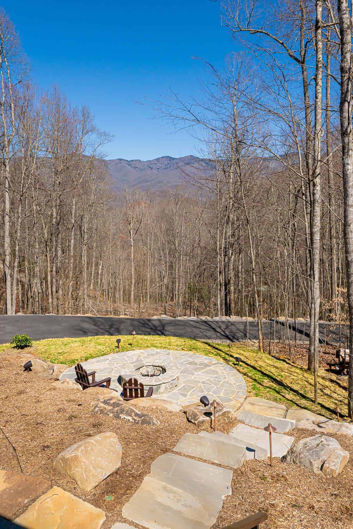 Stone fire pit patio with mountain views and adirondack chairs