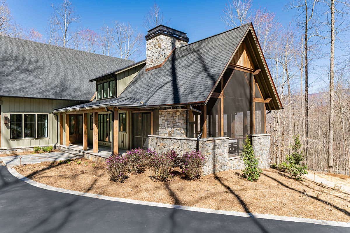 Side exterior with stone chimney and screened porch