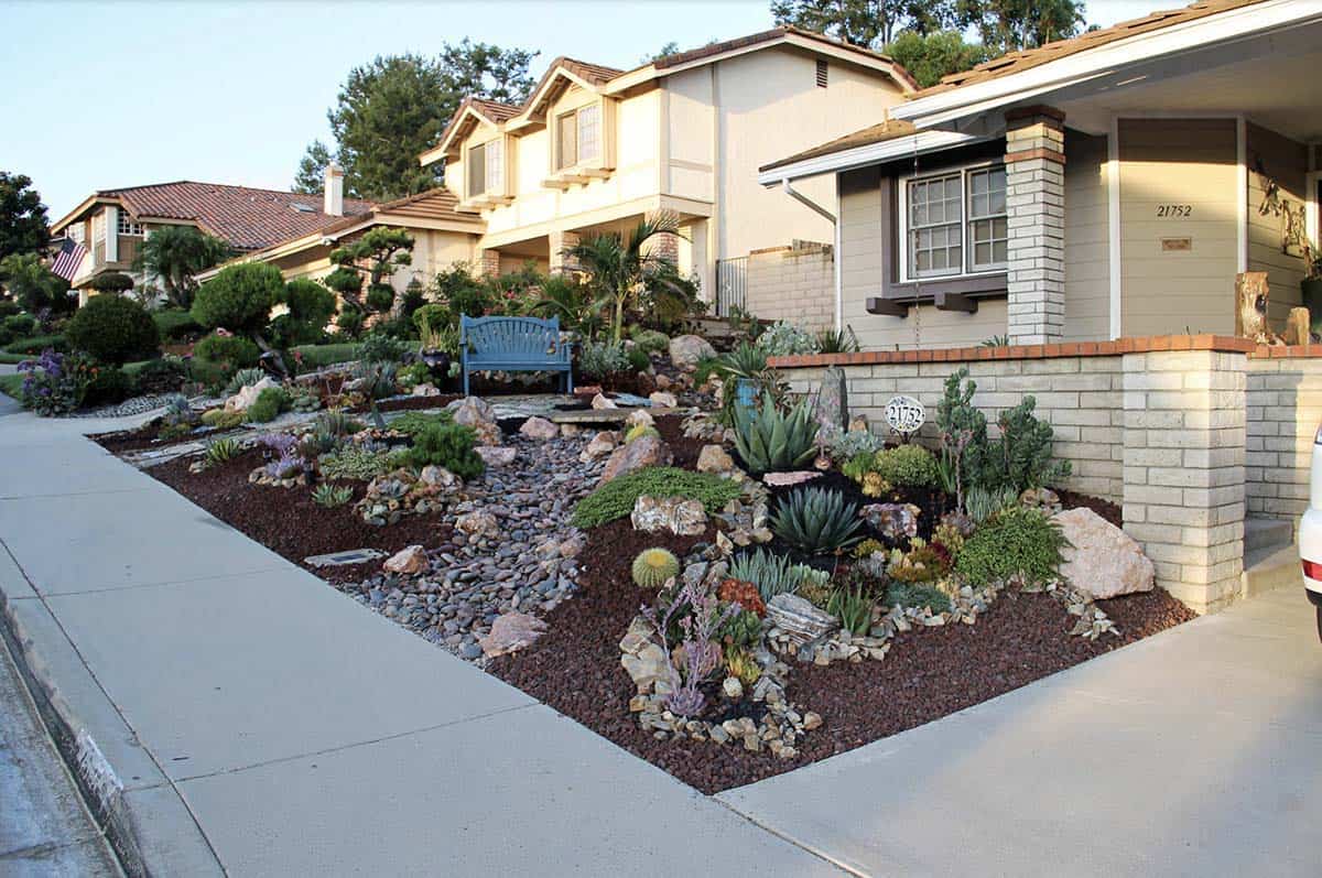 Drought-tolerant front garden with succulents, boulders, and a dry streambed in Orange County, CA