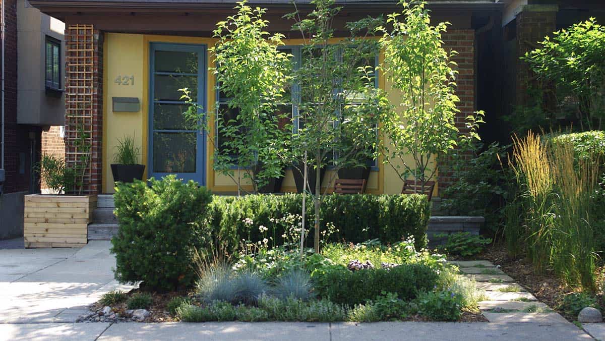 Small urban front garden in Toronto with flagstone pavers and a layered planting square
