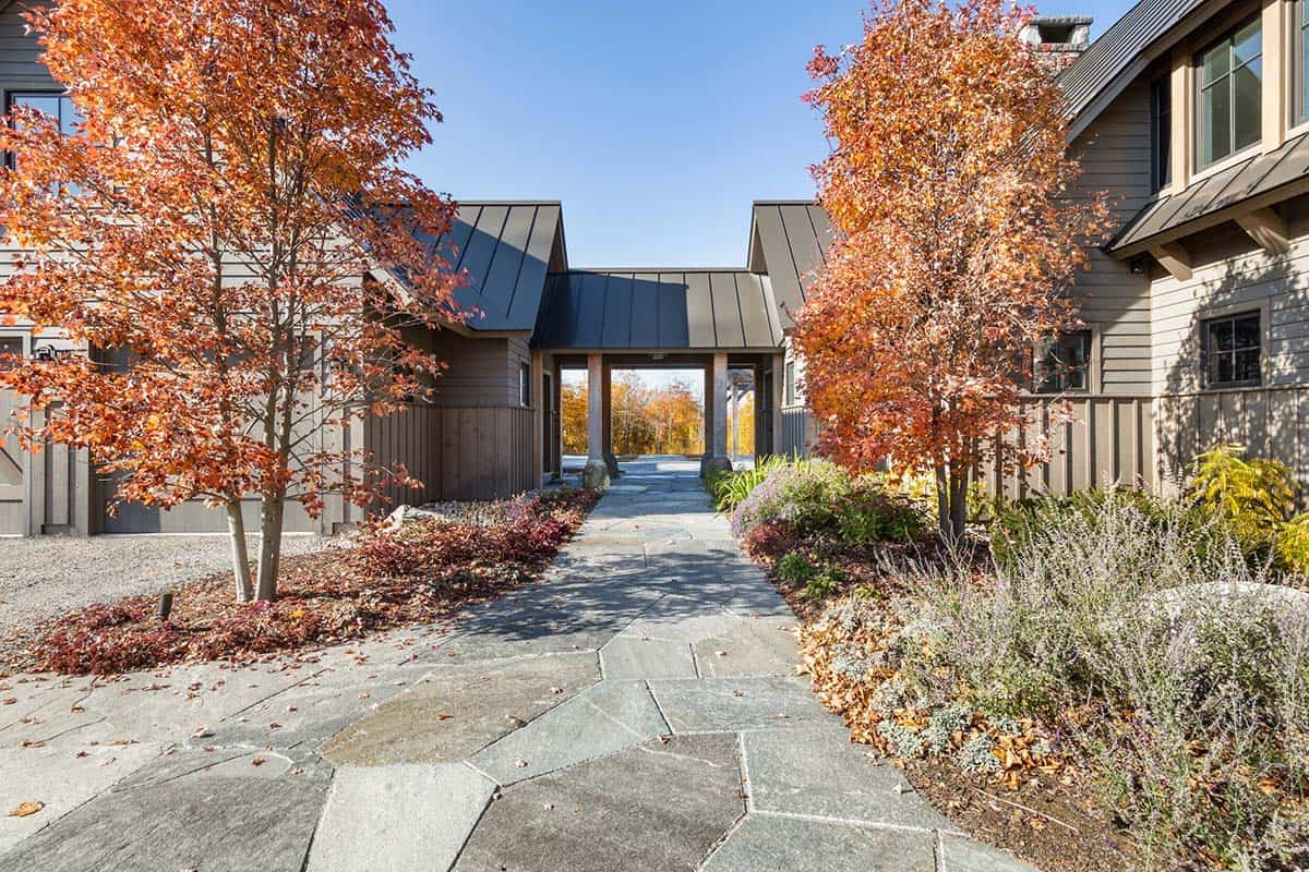 Stone walkway leading to covered timber breezeway flanked by fall foliage