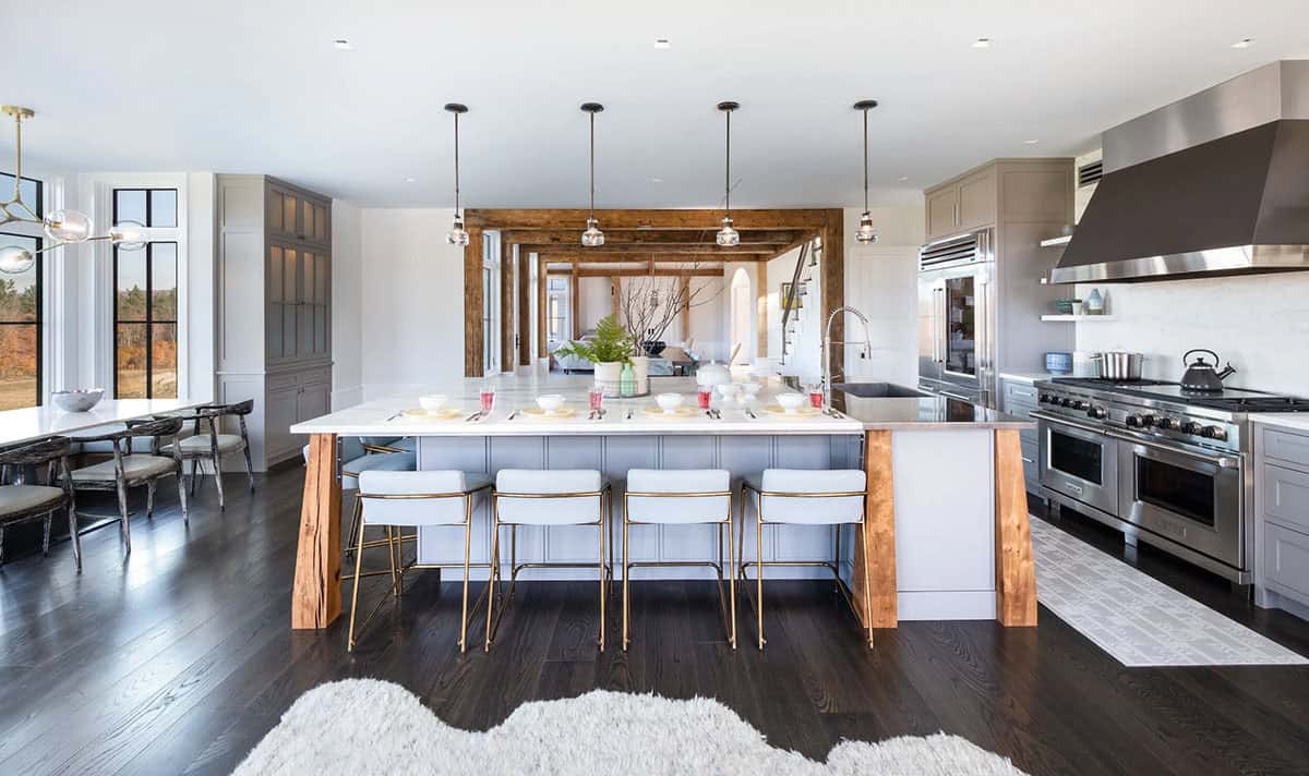 Kitchen island with reclaimed wood legs and view into timber-frame great room
