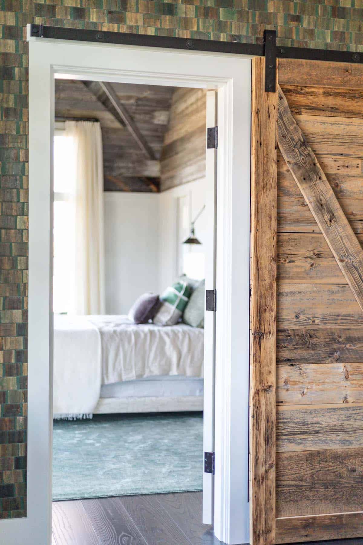Reclaimed barnwood sliding door opening into bedroom