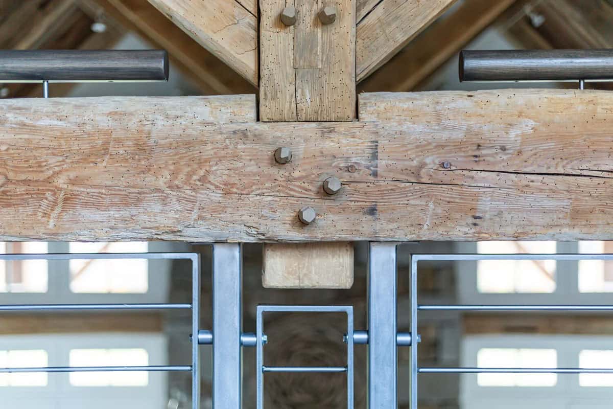 Detail of mortise and tenon timber-frame joinery with steel railing