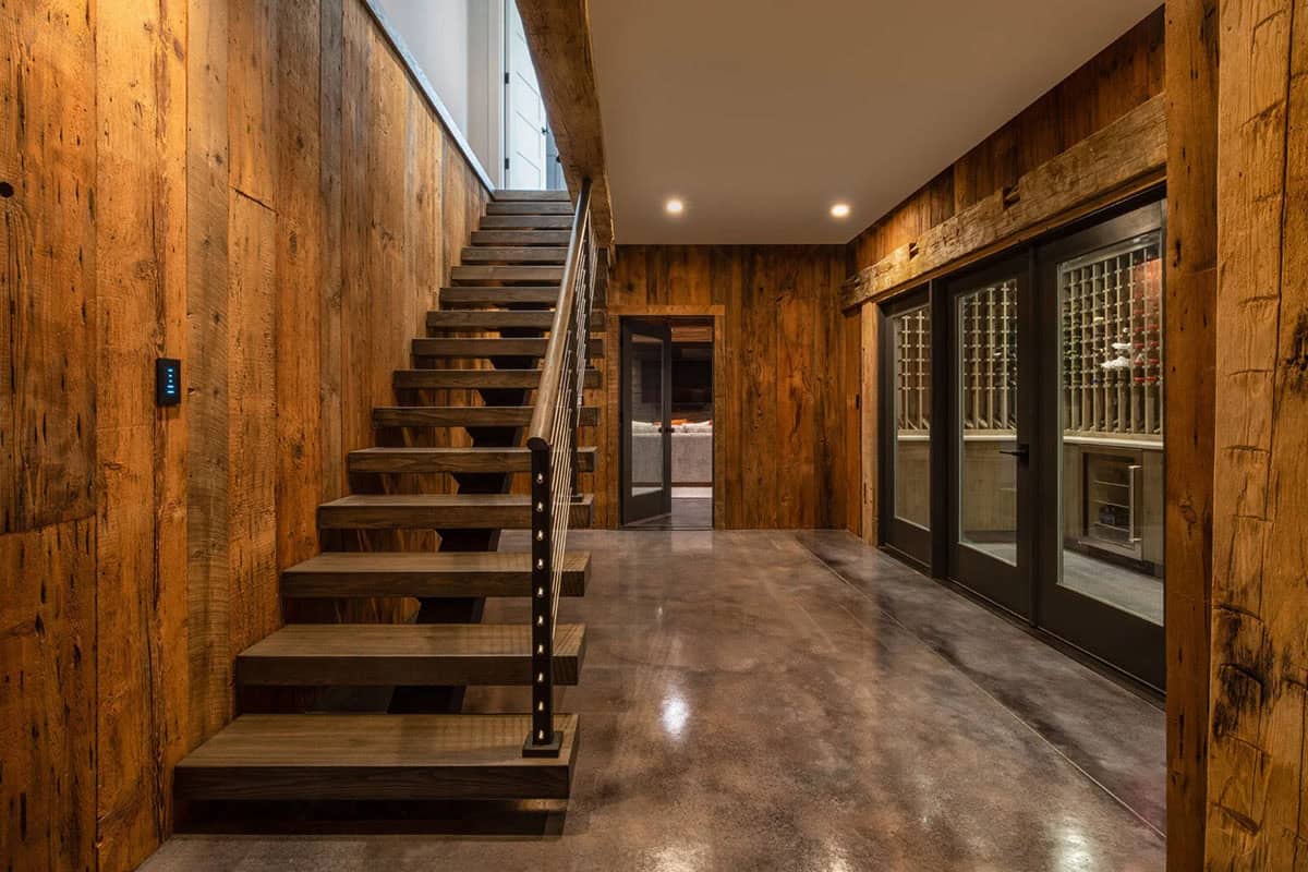 Floating wood staircase with cable railing leading to wine cellar below