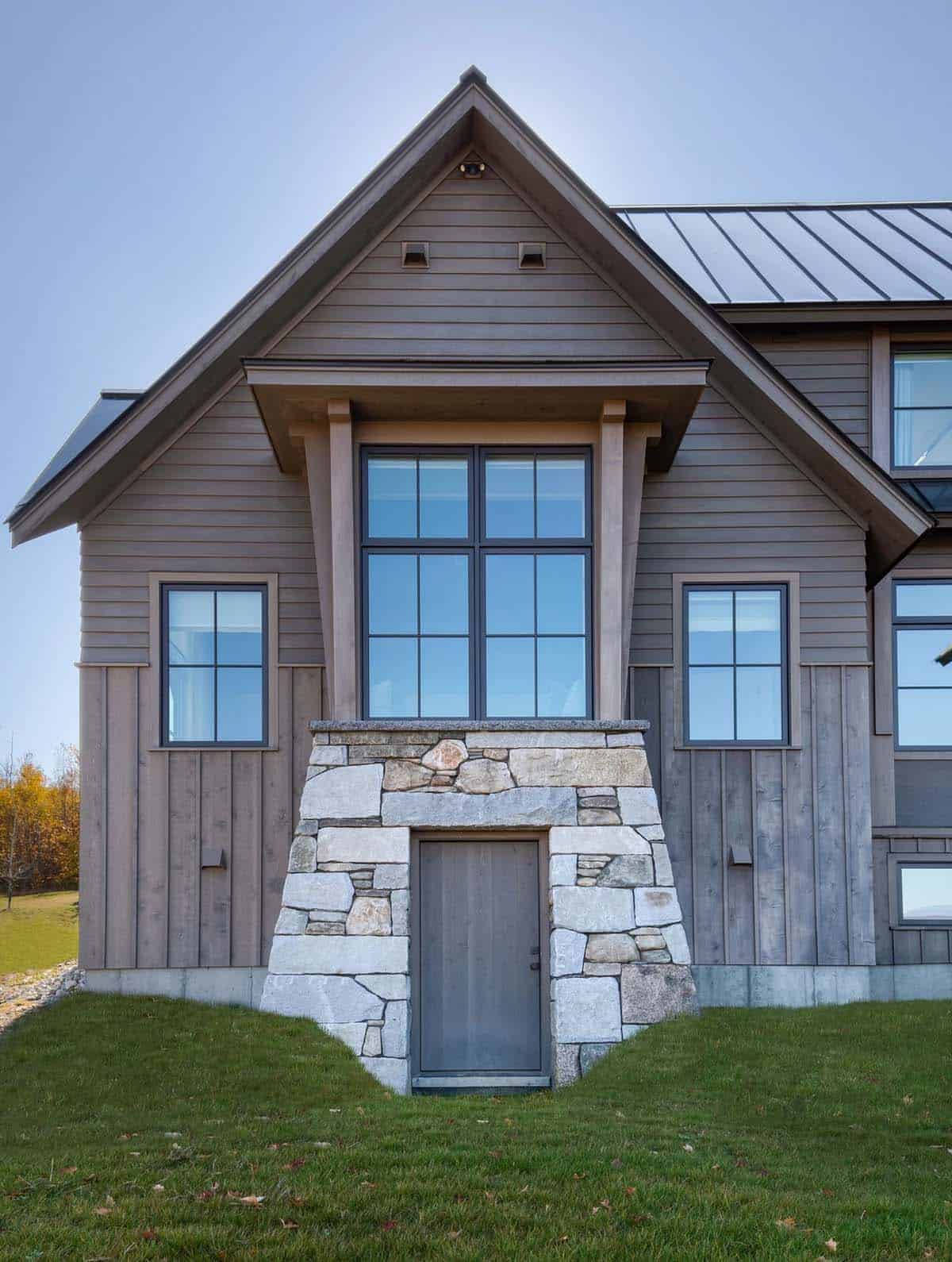 Gable entry with stone surround and timber bracket window above door