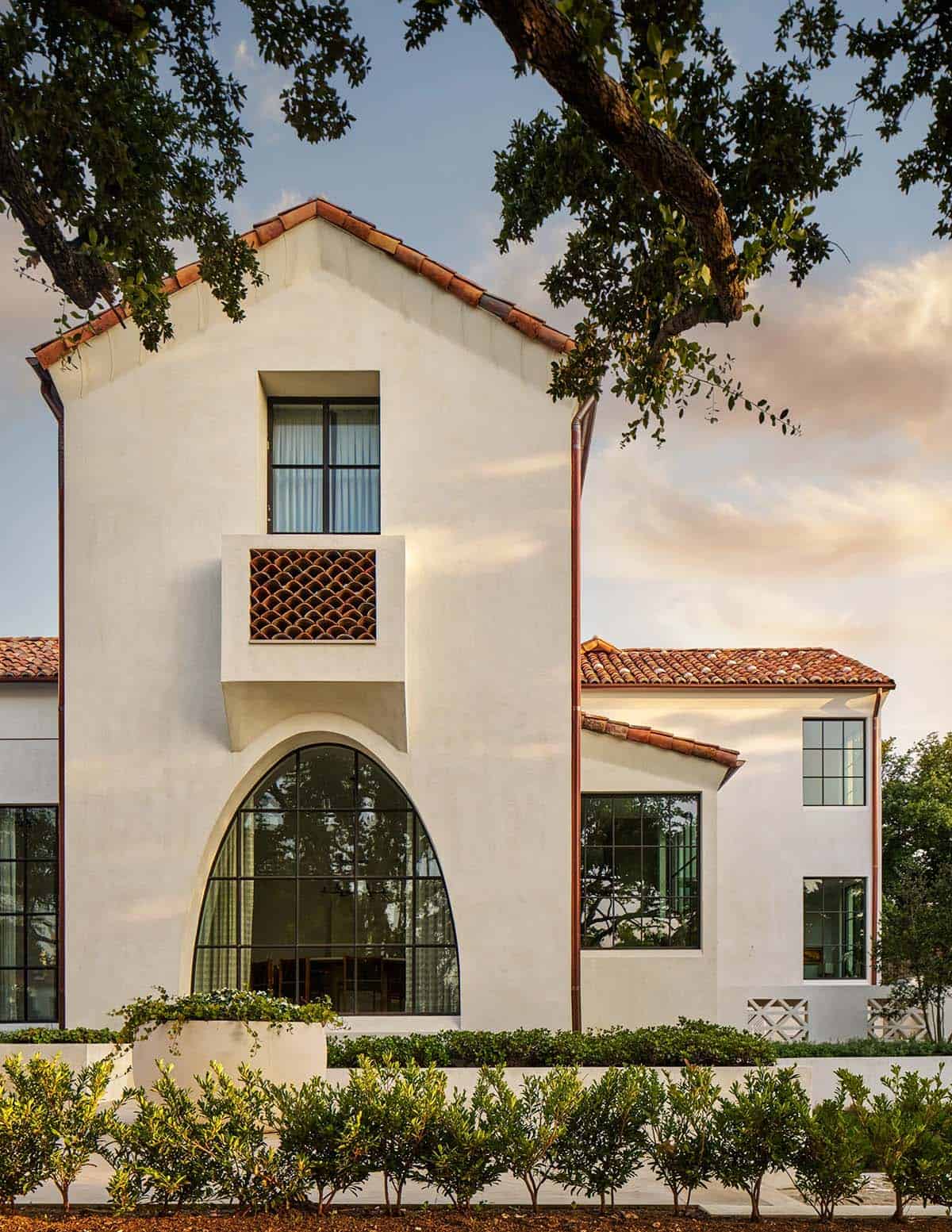 Spanish Colonial Revival home in Texas with arched window and scalloped tile balcony detail