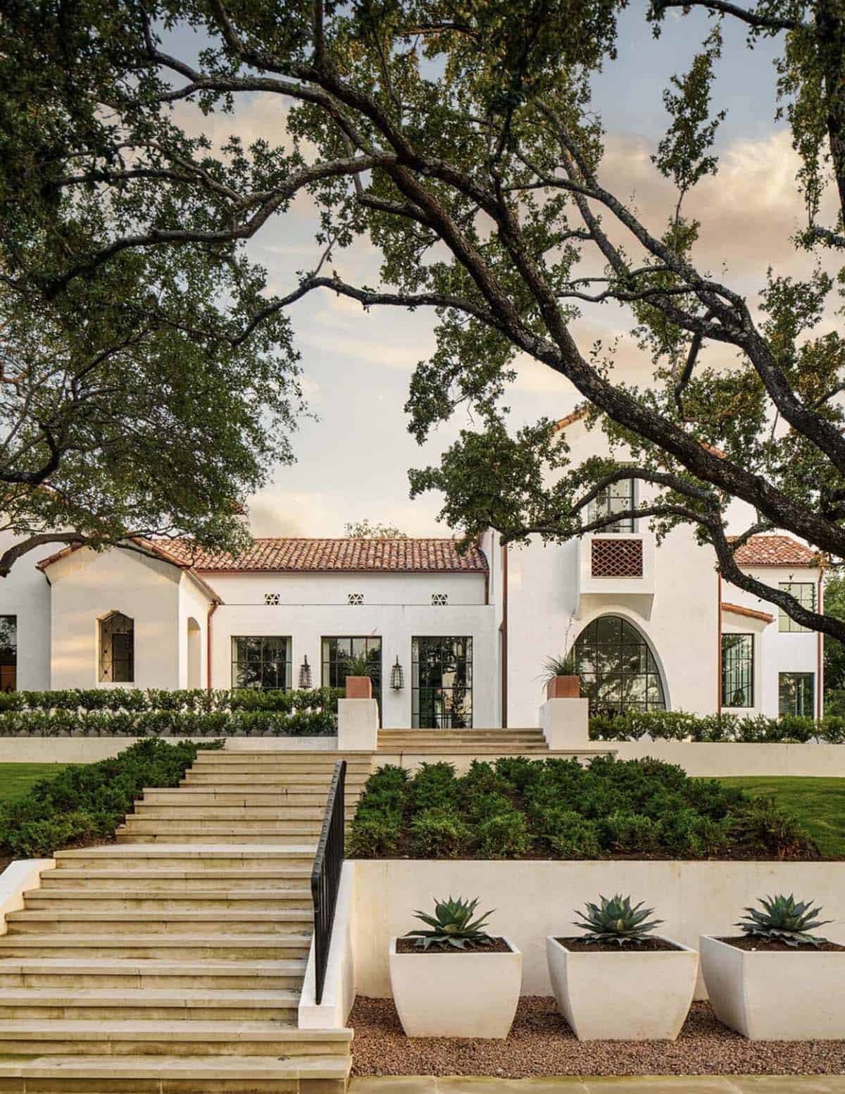 Spanish Colonial Revival home in Texas with stone staircase and agave planters