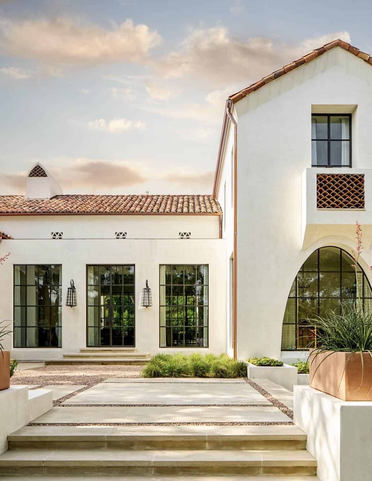Courtyard view of Spanish Colonial Revival home in Texas with steel windows and arched window