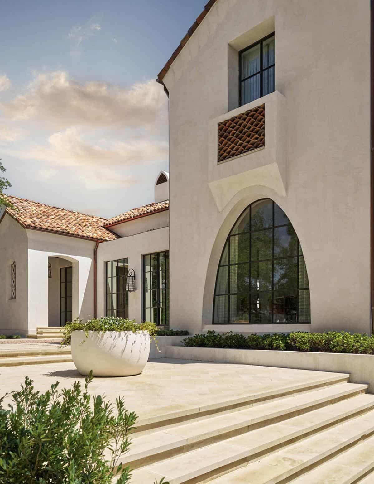 Spanish Colonial Revival home in Texas with arched steel window and stone courtyard