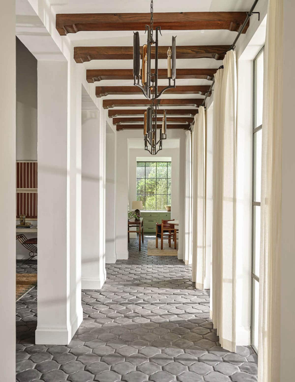 Hallway with wood beam ceiling and arabesque tile floor in Spanish Colonial home