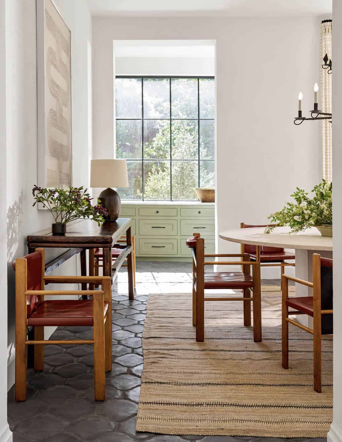 Dining nook with sage green cabinetry and leather armchairs