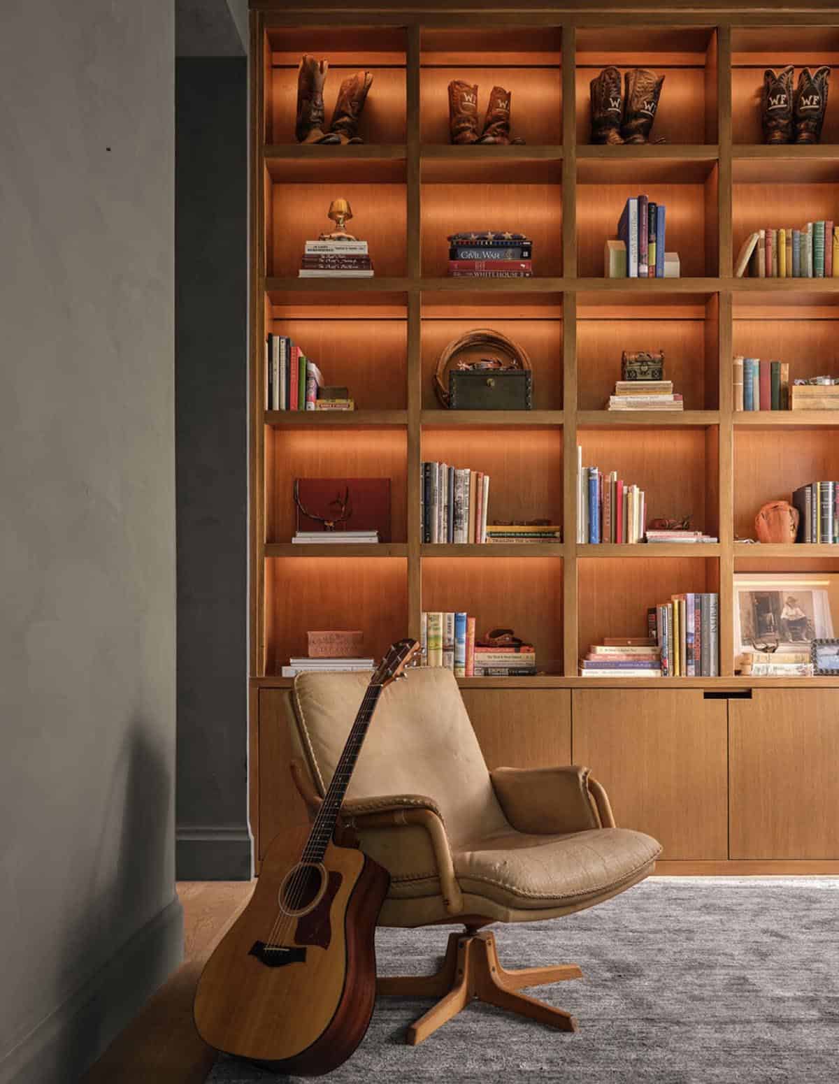 Built-in bookshelves with cowboy boots and leather lounge chair