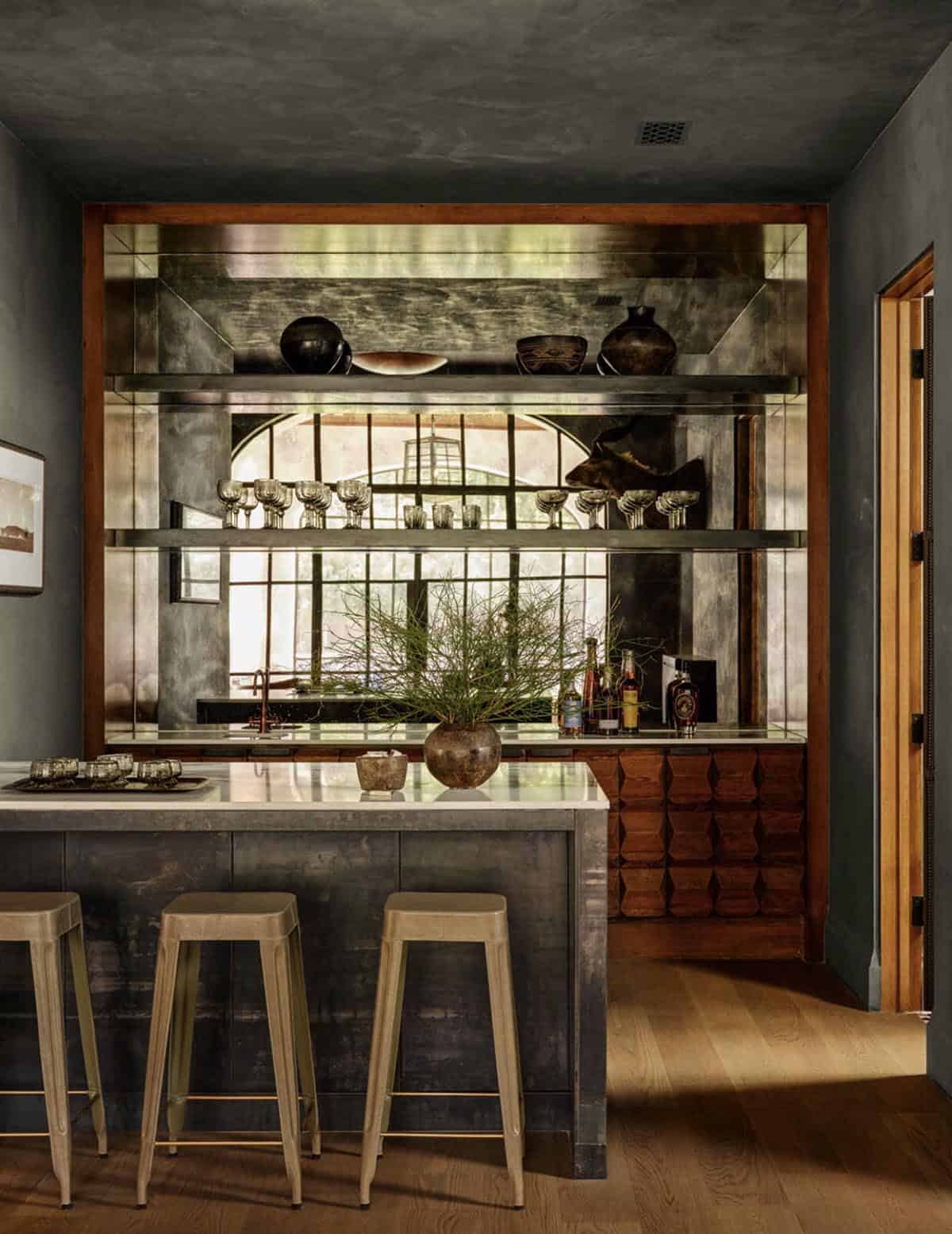 Wet bar with antiqued mirror shelving and wood cabinetry