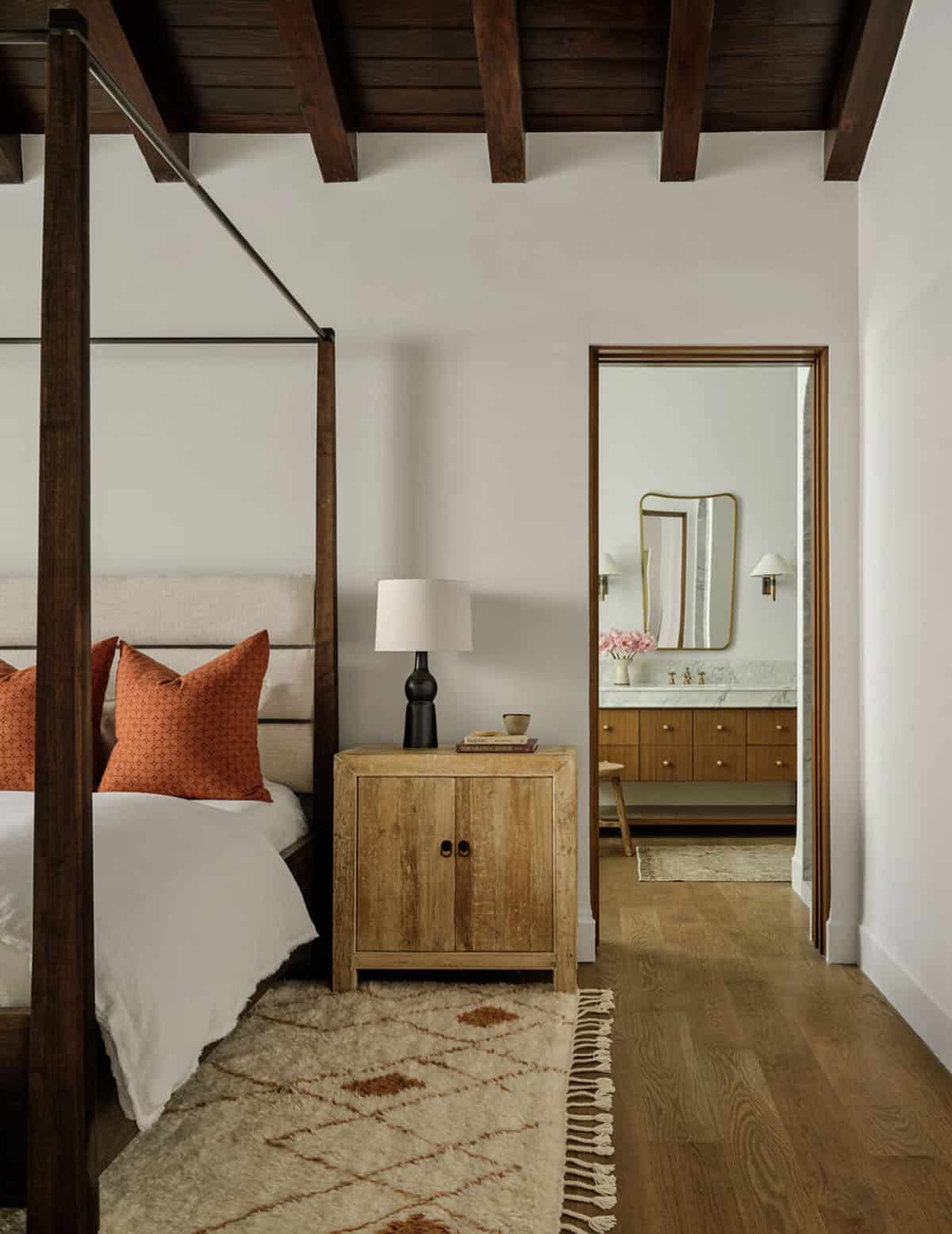 Primary bedroom with canopy bed and en suite bathroom view