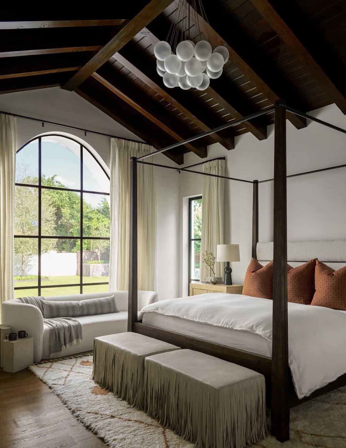 Primary bedroom with arched window and bubble glass chandelier