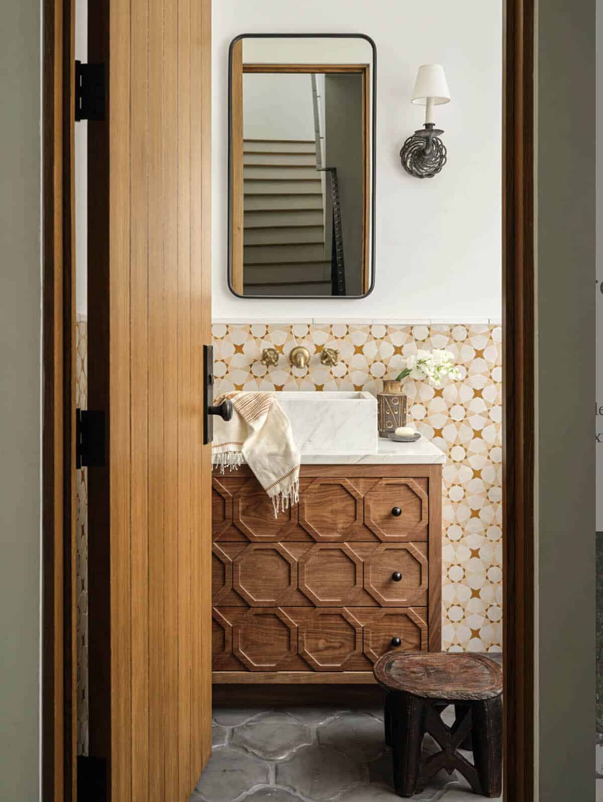 Powder room with octagonal wood vanity and patterned tile backsplash