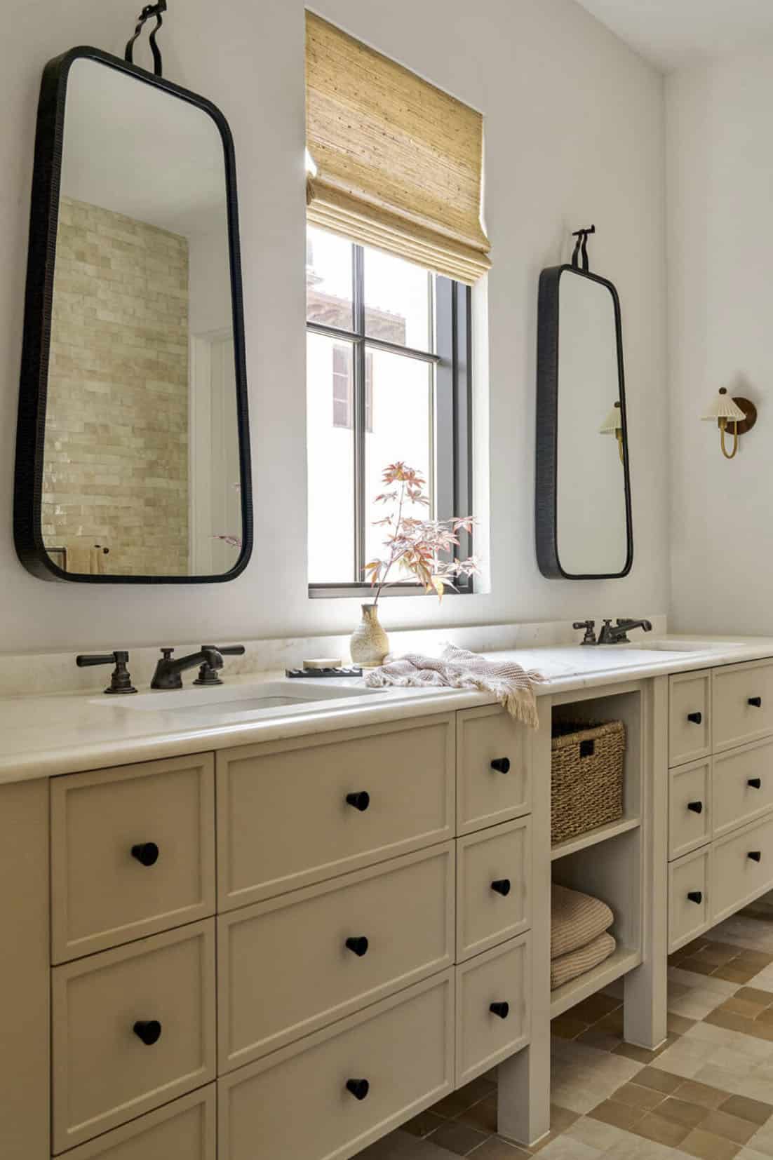Double vanity bathroom with black framed mirrors and patterned tile floor