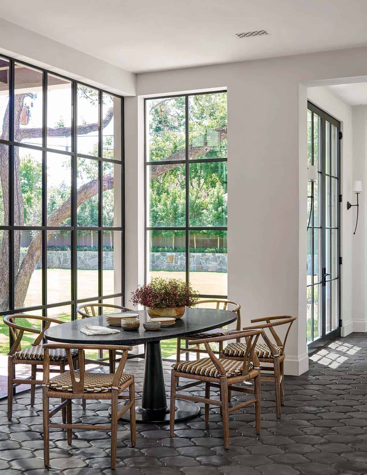 Breakfast nook with wishbone chairs and floor-to-ceiling steel windows