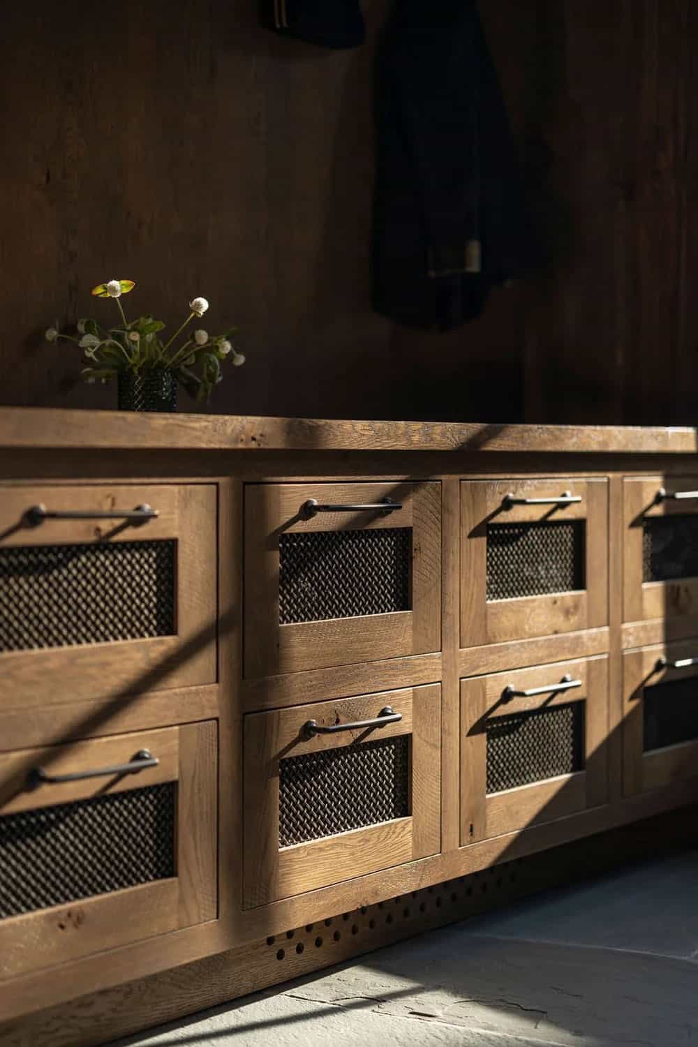Close-up of mudroom cabinet drawers with mesh inserts and iron pulls