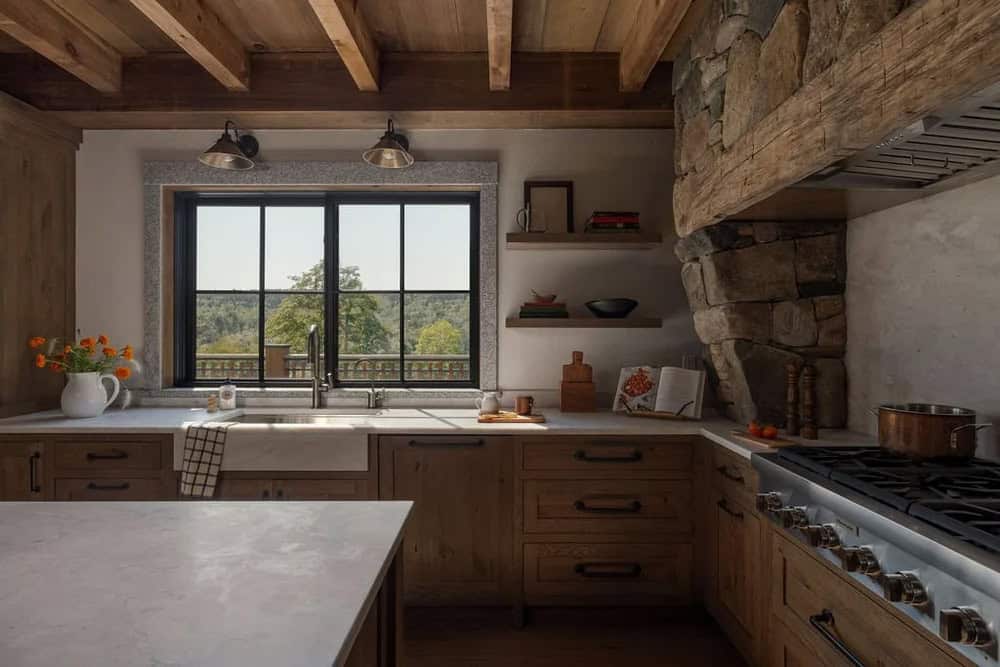 Kitchen sink area with farmhouse sink, stone surround window, and open shelving