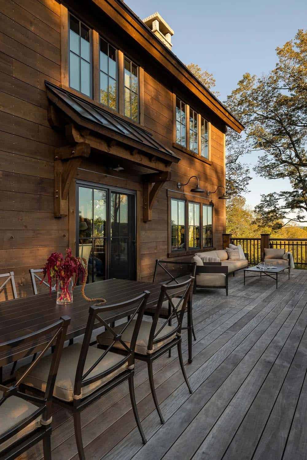 Back deck with outdoor dining table and lounge seating overlooking trees