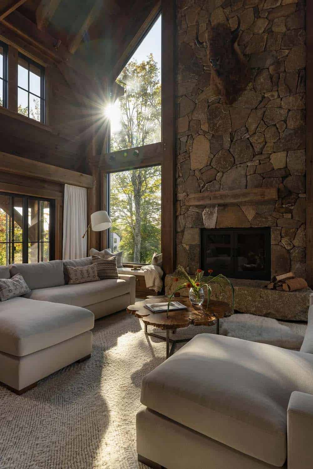 Living room with stone fireplace, mounted bison head, and sectional sofa