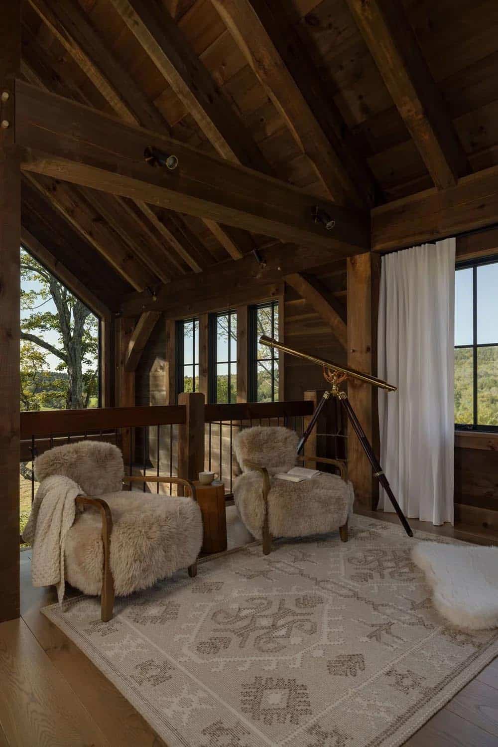 Loft sitting area with shearling chairs, brass telescope, and valley views