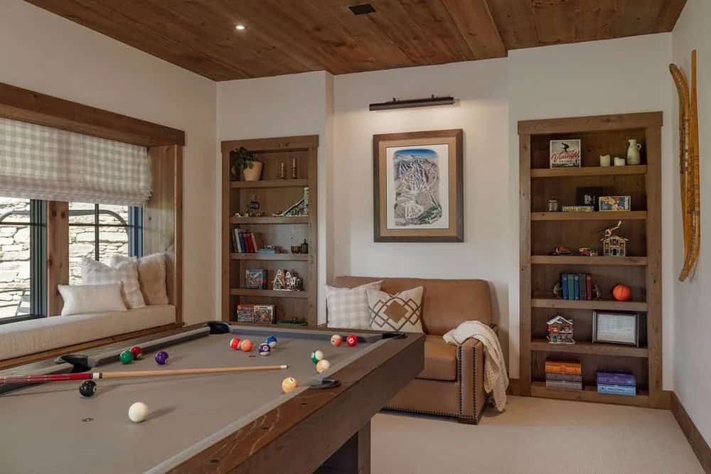 Game room with pool table, built-in bookshelves, and window seat