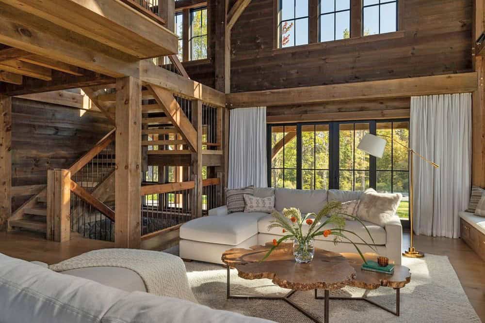 Two-story great room with exposed timber framing, sectional sofa, and live-edge coffee table
