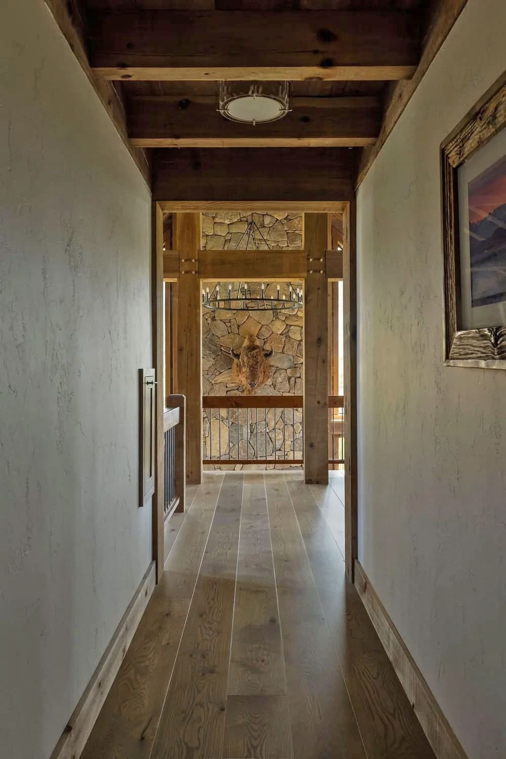 Wood-paneled hallway leading to stone wall with mounted bison head