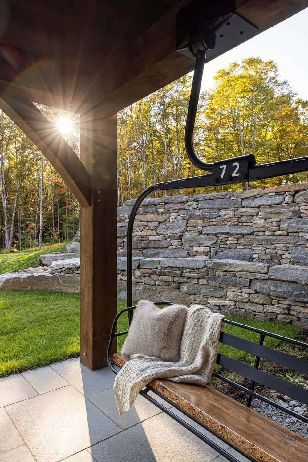 Vintage chairlift bench repurposed as outdoor seating against stone retaining wall